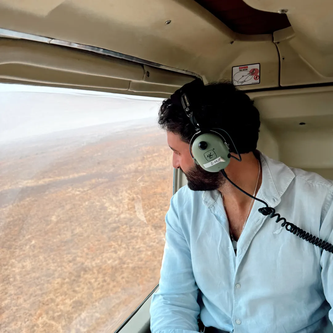 Imagen de Miguel el fundador de Sabana travels en un helicóptero recorriendo áfrica